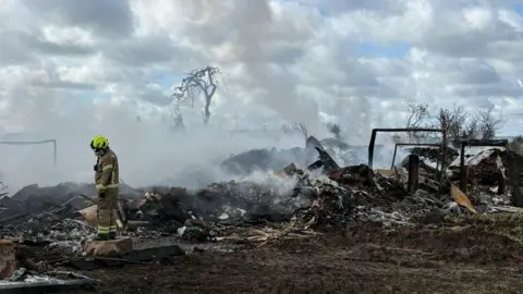 Nottinghamshire Fire and Rescue Service Nottinghamshire Fire and Rescue Service remain at the scene on Tuesday 21 April 2026 at Hathernware Industrial Estate, in Sutton Bonington, after a fire started on 15 April 2026.