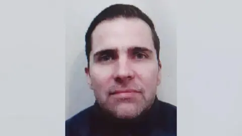 Police image of Steven Stewart who is wearing a dark top and has dark hair.