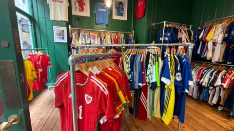 Cowshed Inside a shop with hundreds of vintage football shirts on rails.  