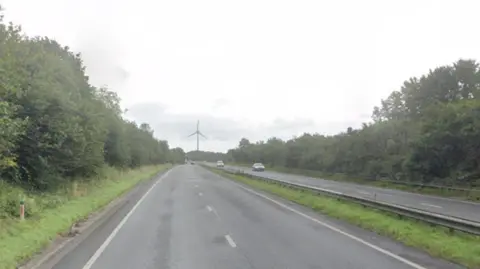 A view down the A30 near the scene of the collision. The picture taken from a mapping website shows the roads clear with a wind turbine in the distance. 