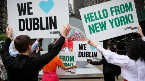 Reuters Public hold up signs in support of portal linking Dublin and New York