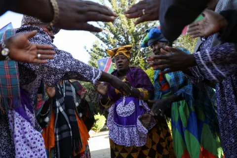 Reuters Women wearing  Ovaherero attire chant and sing at the official ceremony in Windhoek.