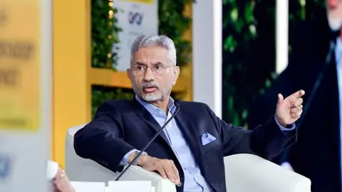 Getty Images India's Foreign Minister S Jaishankar wearing a navy-blue suit over a light blue shirt speaks into a microphone, sitting on an off-white armchair, at an event in Delhi in December 2025.