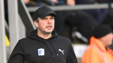 Barrow head coach Stephen Clemence shouting at his players from the touchline during a match