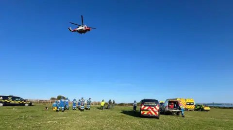 Torbay Coastguard A coastguard helicopter and coastguard teams attending the rescue scene near the cliff fall in Daddyhole