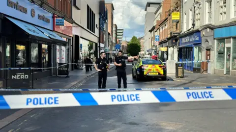Two police officers inside a cordon in Leicester city centre