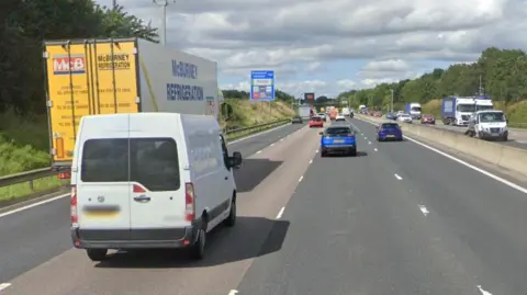 Google streetview of vans and cars on the northbound M6 with sign for Knutsford services at the side of the carriageway