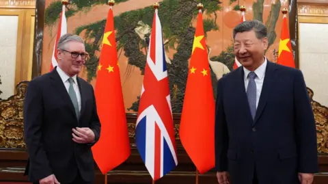 Reuters Keir Starmer stands next to Xi Jinping with British and Chinese flags behind them