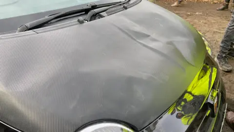 A black fiat car with body damage