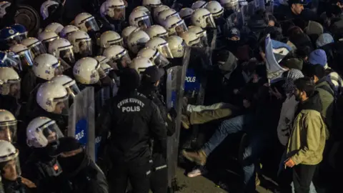 Getty Images Protesters clash with police holding shields in Ankara, Turkey, on Wednesday night.