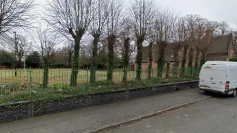 Google A general street view of an old bowling green in Derby, behind a green metal fence.