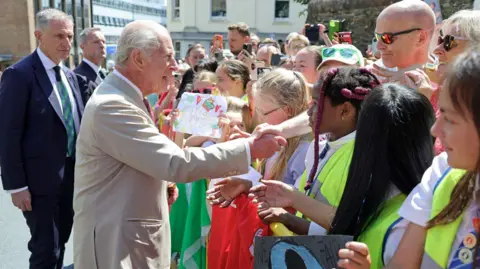 PA Media The King shaking hands with members of the crowd.