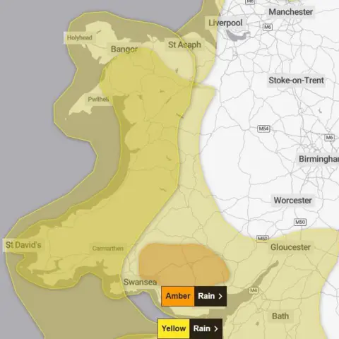 Met Office A graphic showing the map of wales with a yellow warning for wind and another for rain covering much of Wales. An amber warning for rain voers south-east Wales
