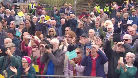 Crowds of people clapping and waving, and taking photographs at the Stockton & Darlington Railway 200th birthday celebrations in Shildon