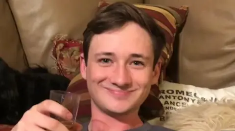 OC Sheriff Blaze Bernstein smiles at the camera while holding a glass in his hand.