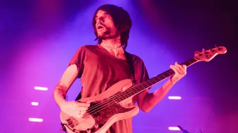 Jonny Greenwood playing the guitar on stage in 2022