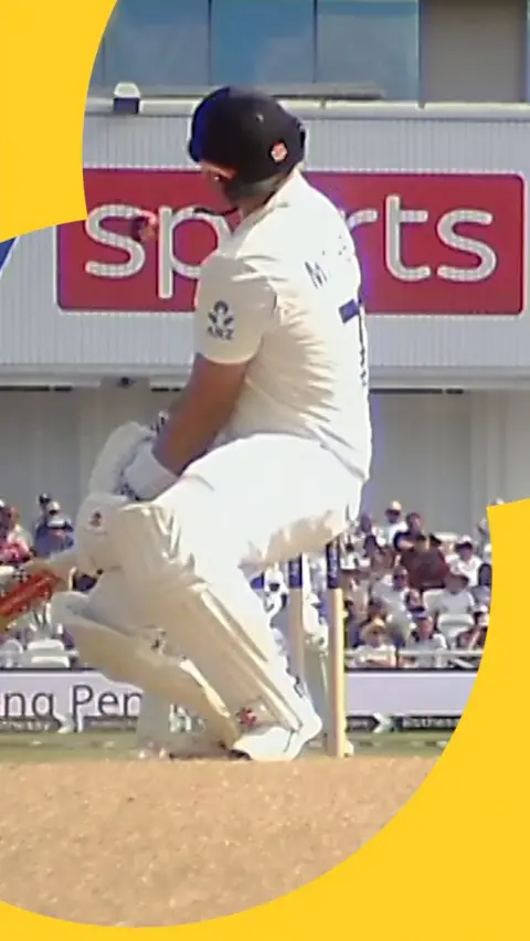 NZ's Daryl Mitchell flinches as he's hit in the face off the bowling of England's Gus Atkinson