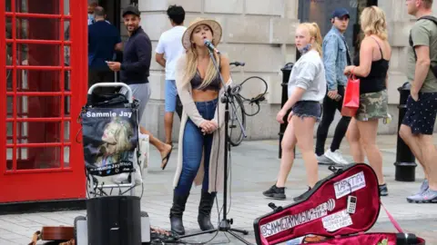 Getty Images Female busker performs in Covent Garden.