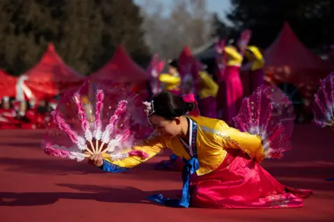 Andres Martinex Casares/EPA-EFE Performers during celebrations for the Chinese Lunar New Year at Ditan Park, or Temple of Earth, in Beijing, China
