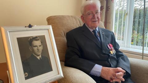 Bill Wake wearing his medals next to a photo of him as a young man