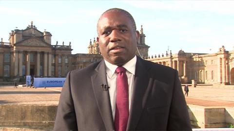 David Lammy wearing a suit and red tie as a speaks to camera during an interview with the BBC live from Blenheim Palace