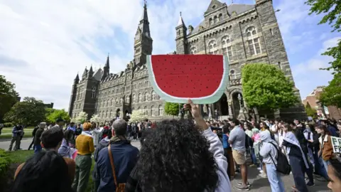 Getty Images A woman holds up the sign of a watermelon to signify support for the Palestinians during a protest against Israel's attack in Gaza at Georgetown University on 25 April 2025