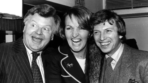 Getty Images A black and white photo of Benny Hill, Penelope Keith, Tommy Steele