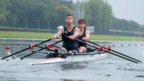 PA Media Great Britain's Gregg Stevenson and Lauren Rowles, wearing dark blue vests and shorts, row in their double sculls boat on the Seine in the PR2 Mixed Double Sculls on day two of the Paris 2024 Summer Paralympic Games