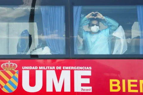 A person makes a heart shape with his hands while riding a bus transporting passengers from the MV Hondius cruise ship to Tenerife South Airport from the Port of Granadilla de Abona in Tenerife, Spain, 11 May 2026.