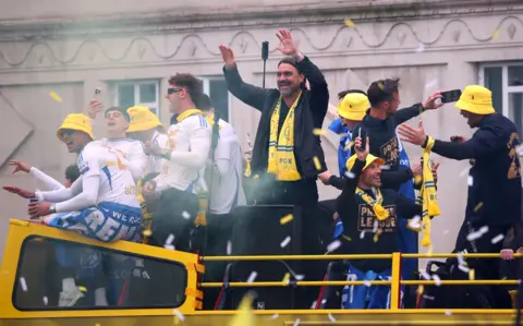 Reuters / Ed Sykes Staff and players cheer from the top decks of the three buses