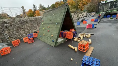 Katie Underwood A playground with little plastic crates and wood blocks all strewn across the place. 