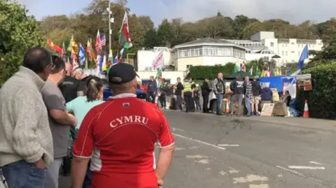 BBC Protesters gather outside the Stradey Park Hotel in Llanelli when plans to use it for temporary housing for  asylum seekers was announced.