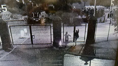 Foyle College Two figures are seen climbing school gates in the dark
