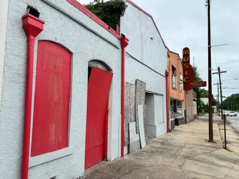 Brandon Drenon/BBC A row of deserted buildings on Tuskegee's South Main Street 
