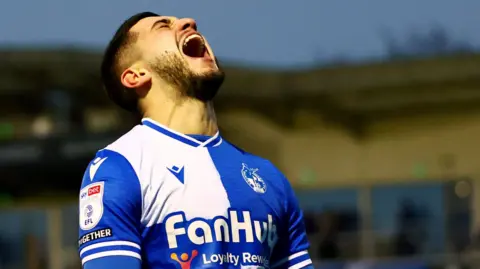 Bristol Rovers FC Bristol Rovers player Ruel Sotiriou shouts as he looks to the sky after scoring the third goal in Rovers' 3-1 win over Barnsley at the Memorial Stadium. It is after dark and the blurry main stand can be seen in the background