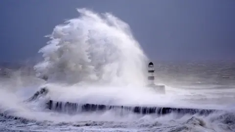 PA Media Waves crash against the lighthouse in Seaham Harbour, County Durham