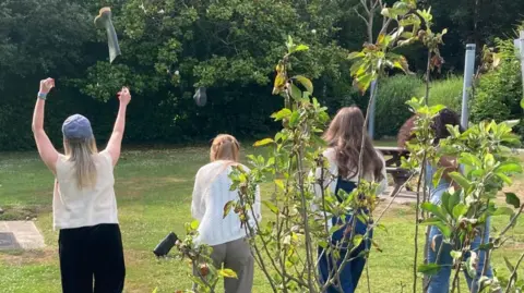 BBC Four women throwing wellington boots across a grassy field