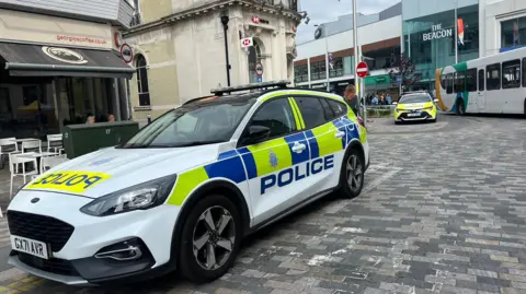 Two police cars parks outside an HSBC bank