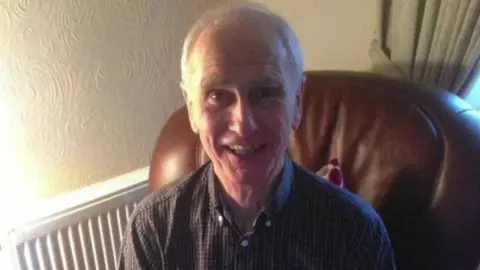 Family handout Don Taylor is sitting on a leather armchair in a living room, and he has a big smile on his face. 