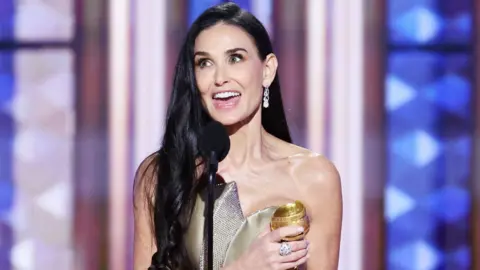 Demi Moore accepting Golden Globe award on stage