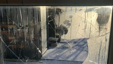 Yvonne Allen Picture of the smashed window of the cabin on the allotment site. The glass is partly-smashed.