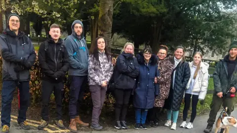 Lauren Murphy A group of people in walking clothes pose for a photo