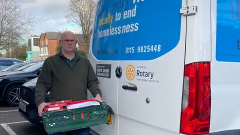 The Friary Ben Talbot, with a tray of supplies, stood next to a transit van