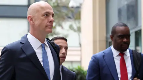Paul Schmidt, a lead attorney for Meta, heads into an Oakland, California courthouse for the first day of trial in a major lawsuit against the company brought by several state attorneys.