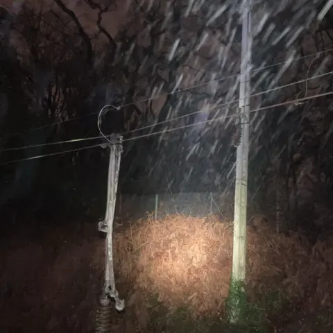 Network Rail A damaged power line, in darkness with driving rain