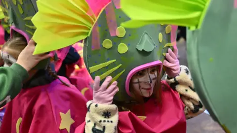 Stuart Walker A child dressed in a green and pink costume for a carnival