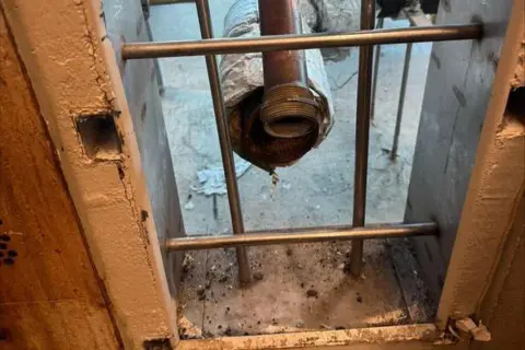 Orleans Parish Sheriff's Office A hole in a prison cell with a pipe visible behind bars
