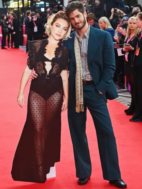 Getty Images Andrew Garfield (po prawej) pozuje z tekturową wycinką Florence Pugh podczas gali Headline "Żyjemy w czasie" podczas 68. BFI London Film Festival w The Royal Festival Hall 16 października 2024 r. w Londynie, Anglia