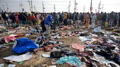 EPA Devotees walk near mixed fabrics on the ground following a stampede accident during the Kumbh Mela festival near Sangam Ghat Prayagraj, Uttar Pradesh, India, 29 January 2025. 