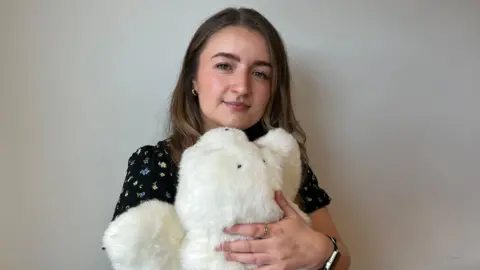Dr. Sharna Bennett holds a furry robotic seal against her chest